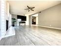 Open living room featuring a brick fireplace, tile floors, and a ceiling fan for added comfort and style at 2600 Congress Ave, Las Vegas, NV 89121