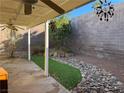 Small backyard with covered patio, artificial turf, and rock landscaping at 3624 Townsend St, Las Vegas, NV 89121