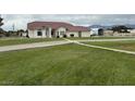 A spacious single-story home with stucco exterior, tile roof, and a large manicured lawn at 390 China St, Pahrump, NV 89048