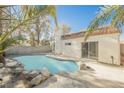 Inviting swimming pool surrounded by rocks in backyard at 5436 Red Sun Dr, Las Vegas, NV 89149