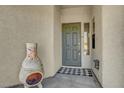 Inviting front entryway with a covered porch, stylish door, and unique decorative accents at 5919 Pavilion Lakes Ave, Las Vegas, NV 89122