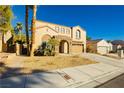 Two-story house with tan exterior, stone accents, and a three-car garage at 9904 Garamound Ave, Las Vegas, NV 89117