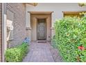 Front entry with brick walkway and lush green shrubs at 10375 Pescado Ln, Las Vegas, NV 89135