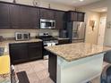 Stylish kitchen features granite counters, stainless steel appliances, and an island with bar seating at 181 Elexese Ct, Las Vegas, NV 89183