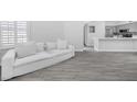 Spacious living room with large off-white couch and gray wood-look floor at 2251 Wigwam Pkwy # 218, Henderson, NV 89074