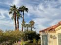 View of home's exterior and surrounding palm trees at 5400 Paul Kurtz Way # 102, Las Vegas, NV 89108
