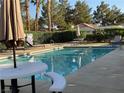 Community pool with lounge chairs, patio furniture, and umbrellas at 5400 Paul Kurtz Way # 102, Las Vegas, NV 89108