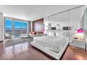 Bright bedroom featuring a king bed, city views, and hardwood floors at 4381 W Flamingo Rd # 3819, Las Vegas, NV 89103