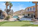 Resort-style backyard oasis with a rock waterfall and putting green at 672 Los Feliz St, Las Vegas, NV 89110