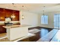 Open concept kitchen with an island, hardwood floors, and modern lighting fixtures at 7154 Steele Canyon St, Las Vegas, NV 89118