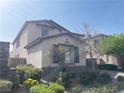 This home features beautiful landscaping and desert foliage around the front of the property at 12243 Pacific Cruise Ave, Las Vegas, NV 89138