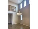 Living room featuring high ceilings, wood look tile floors, and a decorative chandelier at 12243 Pacific Cruise Ave, Las Vegas, NV 89138