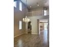 Bright open living space with high ceilings, wood look tile floors, and a decorative chandelier at 12243 Pacific Cruise Ave, Las Vegas, NV 89138
