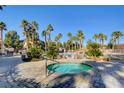 Inviting community hot tub surrounded by lush landscaping and palm trees, perfect for relaxation at 1701 King James St # 101, Las Vegas, NV 89144