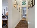 Bright hallway with dark wood floors and framed Gathering photos at 2594 Florida Keys Dr, Las Vegas, NV 89156