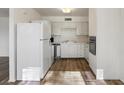 Kitchen with white cabinets, modern appliances, and wood-look floors at 350 E Desert Inn Rd # H208, Las Vegas, NV 89109