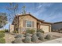 Tan stucco house with stone accents, landscaping, and a two-car garage at 470 Pebble Run Ave, Henderson, NV 89011