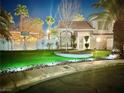 Two-story house with a landscaped yard, palm trees, and nighttime lighting at 9070 Trombone Ln, Henderson, NV 89074