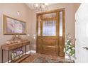 Welcoming entryway with a decorative front door, chandelier, and elegant console table at 2730 El Camino Rd, Las Vegas, NV 89146