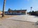 One-story home on a large lot with a concrete driveway in a sparse, desert environment at 3748 Skyline St, Logandale, NV 89021