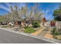 Inviting front of house with mature landscaping, covered entry and secure fenced yard at 4440 E Boston Ave, Las Vegas, NV 89104