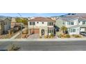 Two-story house with a tan exterior, brown garage door, and landscaping, aerial view at 6833 Desert Finch St, North Las Vegas, NV 89084