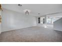 Spacious living room with neutral carpeting and a modern chandelier at 10306 Coastline Creek Ct, Las Vegas, NV 89141