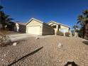 Single-story home with a two-car garage and desert landscaping at 124 Winley Chase Ave, North Las Vegas, NV 89032