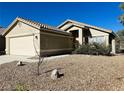 One-story house with a two-car garage and gravel landscaping at 124 Winley Chase Ave, North Las Vegas, NV 89032