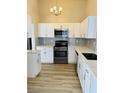 Modern kitchen with white cabinets, quartz countertops, and stainless steel appliances at 124 Winley Chase Ave, North Las Vegas, NV 89032