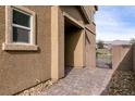 Brick paved walkway leading to a gated side yard at 1642 Dire Wolf Ave, North Las Vegas, NV 89084