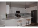 Modern kitchen with white cabinets, gray backsplash, and quartz countertops at 1908 Quail Point Ct, Las Vegas, NV 89117