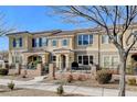 Tan two-story townhome with gray door, and a small front patio with seating at 2077 Via Firenze, Henderson, NV 89044