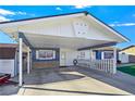 Carport and home entrance with stone accents and white fence at 3169 Nottingham Dr, Las Vegas, NV 89121