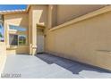 Front entrance with gray concrete patio and white door at 3728 Shallow Dove Ct, North Las Vegas, NV 89032