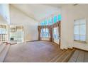 Living room with large windows, vaulted ceiling, and carpeting at 56 Sawgrass Ct, Las Vegas, NV 89113