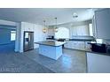 Modern kitchen with an island, stainless steel appliances, and white cabinets at 6335 Rock Stream Ln, Las Vegas, NV 89141