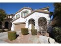 Two-story house with a tan garage door and landscaping at 10418 Prairie Mountain Ave, Las Vegas, NV 89166