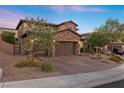 Two-story home with brick exterior, three-car garage, and landscaped yard at 11952 Girasole Ave, Las Vegas, NV 89138