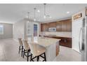 A modern kitchen features dark wood cabinets, stainless steel appliances, granite countertops, and an island with seating at 131 Mosso Niente Pl, Henderson, NV 89011