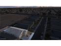 An aerial view shows the roof of a single-story home in a neighborhood with mountain views at dusk at 3540 Valley Lily St, North Las Vegas, NV 89032