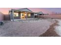 A gravel backyard is enclosed with a block wall and features a covered patio at 3540 Valley Lily St, North Las Vegas, NV 89032