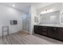 Clean bathroom with double vanity, walk-in shower, and dark wood cabinets at 3540 Valley Lily St, North Las Vegas, NV 89032