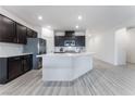 Modern kitchen featuring dark cabinetry, a large island, and stainless steel appliances at 3540 Valley Lily St, North Las Vegas, NV 89032