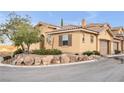 Tan two-story home with a two-car garage and landscaped yard at 4 Via Centrale # 1, Henderson, NV 89011