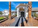 Front entrance with arched entryway and mature palm trees at 4620 Clay Peak Dr, Las Vegas, NV 89129