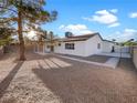 Large backyard with gravel landscaping, covered patio, and mature tree at 4917 E Washington Ave, Las Vegas, NV 89110