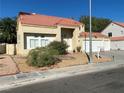 Tan two-story house with tile roof, two-car garage, and desert landscaping at 503 Lariat Ln, Henderson, NV 89014