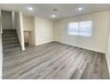 Bright living room with gray vinyl flooring and a view of the staircase at 6124 Jones Cir, Las Vegas, NV 89107