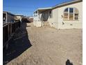 Tan mobile home with covered porch and large windows, side yard view at 6214 Mount Rainier Ave, Las Vegas, NV 89156